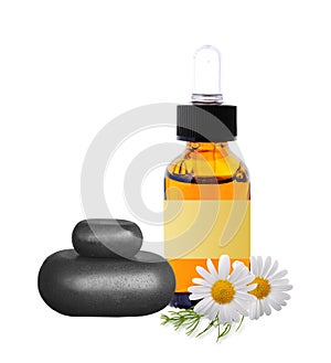 Black spa stones, bottle with essence oil and chamomile flowers