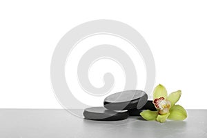 Black spa stones with orchid flower on white background