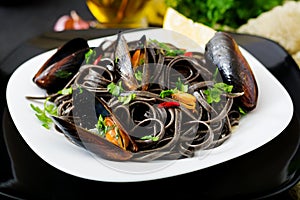 Black spaghetti. Black seafood pasta with mussels over black background.