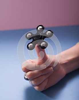 Black spinner balancing on the thumb