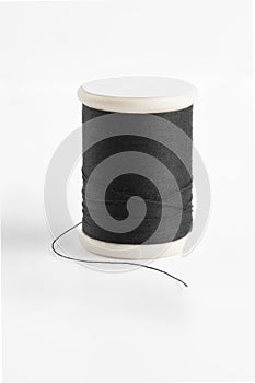 Black spool has shadow on white background.