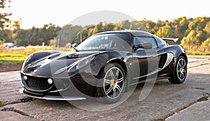 Black sport car on big wheels on nature background