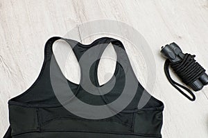 Black sports top and jump rope. Fashionable sports concept