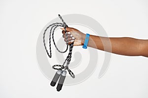 Black sportswoman's hand holding and showing jumping rope