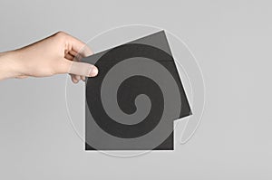 Black Square Flyer / Invitation Mock-Up - Male hands holding black flyers on a gray background