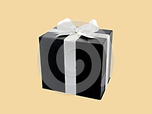 black square shape cardboard gift box with simple white ribbon bow isolated on beige color background