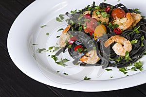 Black squid ink Fettuccine pasta with prawns or shrimps cherry tomatoes, parsley, chili in wine and butter sauce