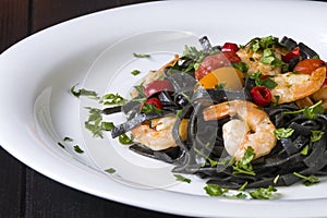 Black squid ink Fettuccine pasta with prawns or shrimps cherry tomatoes, parsley, chili in wine and butter sauce