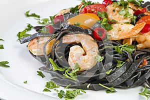 Black squid ink Fettuccine pasta with prawns or shrimps cherry tomatoes, parsley, chili in wine and butter sauce