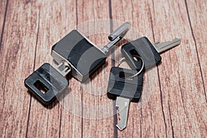 Black steel padlock with keys on a wooden background. Concept of security and tranquility