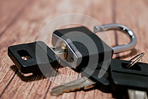 Black steel padlock with keys on a wooden background. Concept of security and tranquility