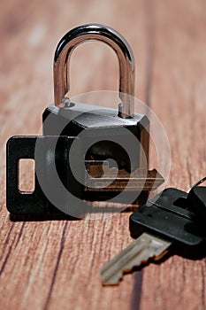 Black steel padlock with keys on a wooden background. Concept of security and tranquility photo