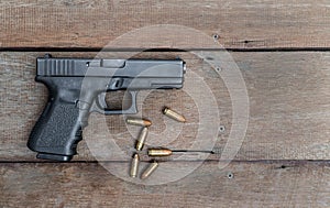 Black steel polymer semi-automatic 9mm pistol on wooden background with Copy Space