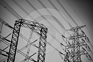 The black steel structure of the high-voltage pole and electric power transmission line is a high-voltage power station in the