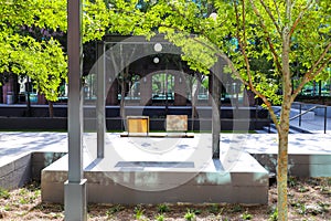 A black steel and wooden swing set in the park surrounded by lush green trees and office buildings at Lenox Park