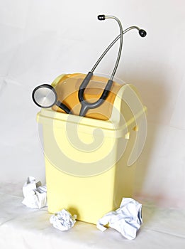 Black Stethoscope discarded in Small Yellow Plastic Trash Can