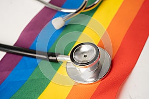 Black stethoscope on rainbow flag background, symbol of LGBT pride month celebrate annual in June social, symbol of gay, lesbian,