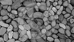 Black stone background. Shiny black lava pebbles on the beach