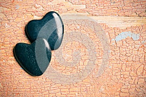Black stone hearts on old cracked background