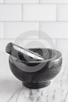 Black Stone Mortar and Pestle on a Marble Countertop