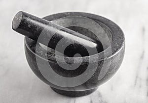 Black Stone Mortar and Pestle on a Marble Countertop