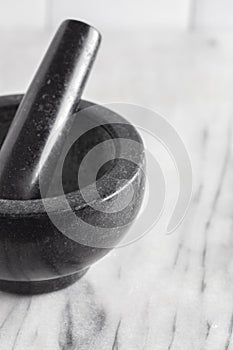 Black Stone Mortar and Pestle on a Marble Countertop