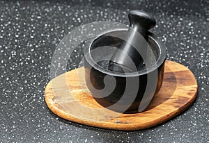 Black stone mortar and pestle on a wooden stand