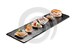 Black stone rectangular tray with shrimp tartare snack cannoli swordfish ravioli with robbiola tartina nordica mousse aubergine photo