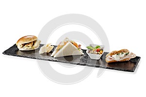 Black stone rectangular tray with snack Pretzel turkey flaky cheese sandwiches salmon pearl spelled vegetables milk sandwiches