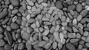 Black stone background. Shiny black lava pebbles on the beach