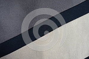 Black stripe sewn to grey and beige fabric diagonally