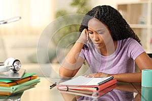 Black student studying memorizing notes at home photo