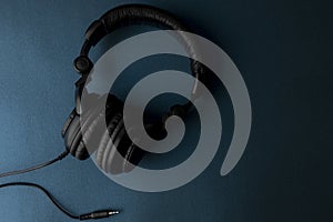 Black studio headphones with blue background and space for text photo