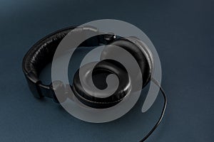 Black studio headphones with blue background and space for text photo