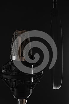 Black studio microphone on black background, close up