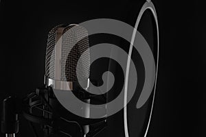 Black studio microphone on black background, close up