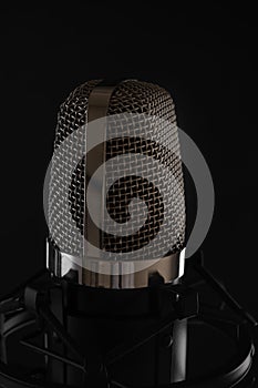 Black studio microphone on black background, close up
