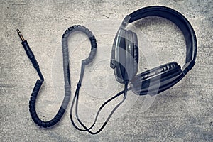 Black studio retro headphones on gray background, professional earphones
