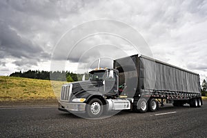 Black stylish big rig semi truck for local haul transporting car