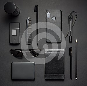 Black stylish male accessories kit on dark background. Top view