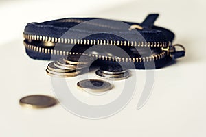 Black suede leather wallet on white background with coins