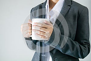 Black suit bussiness women holding a cup of coffee in break time