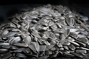 Black sunflower seeds texture on dark background