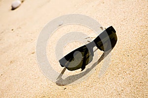 Black sunglasses on the sand