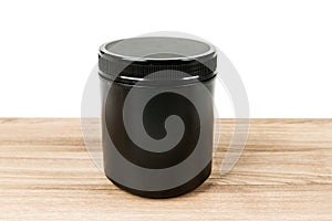 Black supplement tub on a wood patterned background