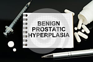 On the black surface are pills, a syringe and a notebook with the inscription - Benign Prostatic Hyperplasia
