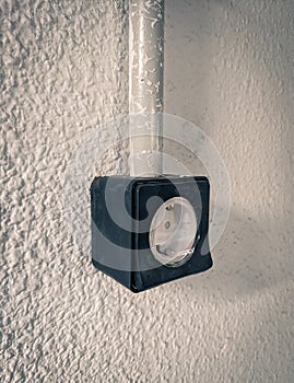 Black surface plug on wall in garage