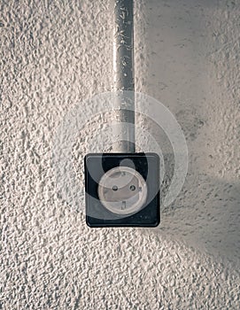 Black surface plug on wall in garage