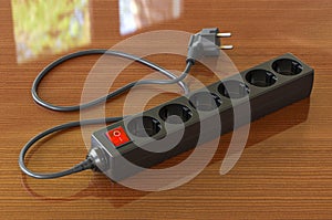 Black surge protector or spike suppressor on the wooden table, 3D rendering