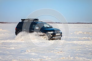 Black SUV moving fast on snow